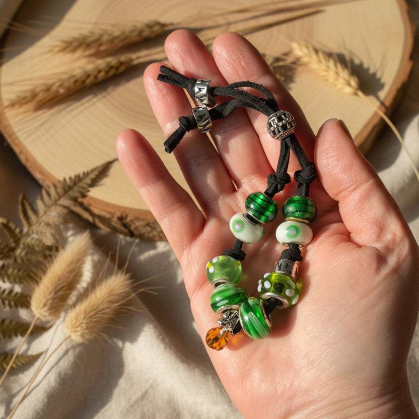 Handmade green glass charm bracelet with silver metal elements and a black suede strap