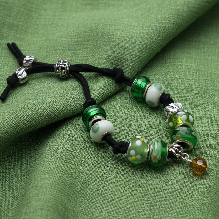 Handmade green glass charm bracelet with silver metal elements and a black suede strap